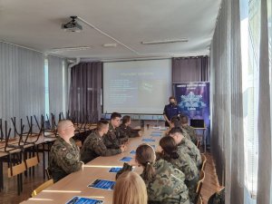 Policjantka omawia z uczniami zjawisko handlu ludźmi na podstawie prezentacji multimedialnej