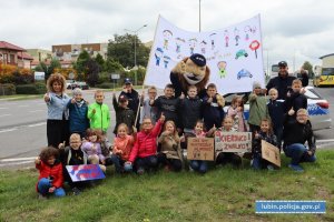 Zdjęcie grupowe dzieci z policjantami i komisarzem lwem