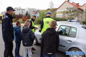 Policjanci z dziećmi przy samochodzie