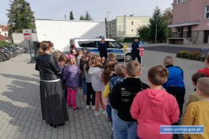 Policjanci przed szkołą prowadzą prelekcję dla uczniów