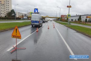 Miejsce wypadku z udziałem osób pieszych. Na jezdni radiowóz, samochody biorące udział w zdarzeniu