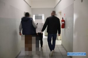 Policjanci prowadzą zatrzymanego