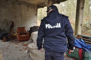 Policjant podczas sprawdzania miejsc przebywania osób bezdomnych