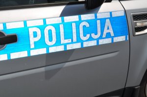 Napis policja na drzwiach radiowozu