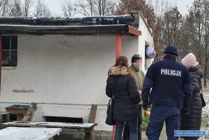 Dzielnicowy i pracownicy socjalni rozmawiają z osobą bezdomną