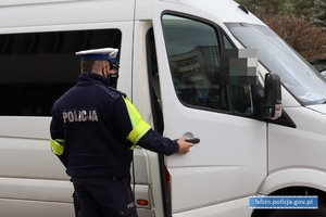 Policjanci kontrolują busa przewożącego pasażerów