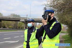 policjanci mierzą prędkość przy drodze