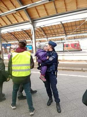 Policjantka z dzieckiem na rękach