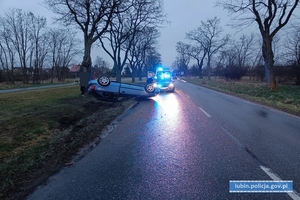 Samochód osobowy na dachu. W tle radiowóz i karetka