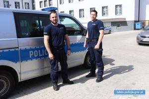 Policjanci stoją przy radiowozie