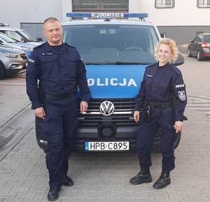 Policjantka i policjant przy radiowozie