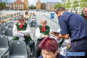 Policjant rozdaje ulotki seniorom