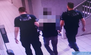 Policjanci prowadzą mężczyznę podejrzewanego o jazdę pod wpływem alkoholu