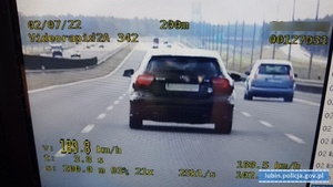 samochód osobowy koloru czarnego na wyświetlaczu wideorejestratora. W dolnym lewym roku prędkość zmierzona 189 km/h