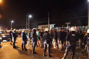 Kibice Śląska Wrocław stoją przy i na peronie stacji Lubin Stadion, wokół kibiców znajdują się policjanci