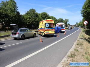 Pojazdy służb ratowniczych na miejscu wypadku drogowego i samochód osobowy sprawcy potrącenia osoby pieszej