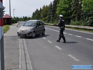 Policjant ruchu drogowego zatrzymuje kierującego pojazdem do kontroli drogowej