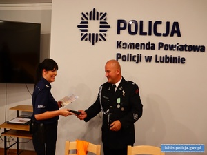 Policjantka odbiera podziękowania od Prezesa Ochotniczej Straży Pożarnej