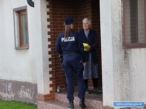 Policjantka przekazuje kamizelkę kobiecie