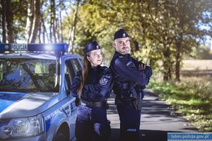 Policjant i policjantka przy radiowozie