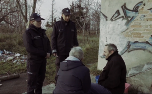 Policjanci rozmawiają z osobami bez stałego miejsca zamieszkania