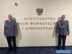 Odznaczeni policjanci przy tablicy z napisem Ministerstwo Spraw Wewnętrznych i Administracji