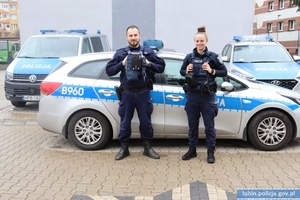 Policjantka i policjant przy radiowozie