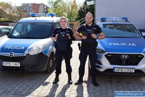 Policjantka i policjant przy radiowozie