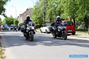 Policjanci na motocyklach pilotują uczestnika biegu