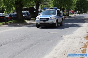 Policjant w radiowozie pilotuje uczestników biegu