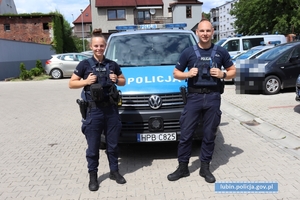 Policjantka i policjant przy radiowozie