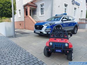 Autko dziecięce odzyskane przez policjantów i w tle radiowóz