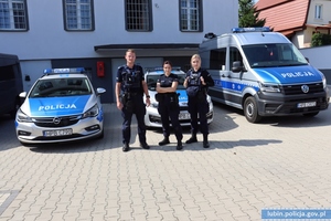 Dwie policjantki i policjant przy radiowozach