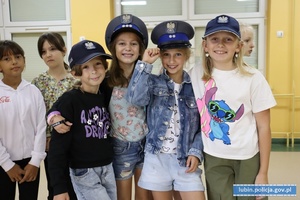 Dziewczynki w policyjnych czapkach na głowach