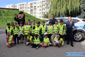 Dzieci z komisarzem lwem i policjantami przy radiowozie