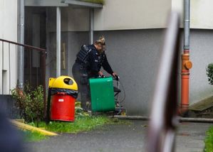 Policjantka wyprowadza kobietę z bloku, w którym wybuchł pożar 
Fot. Lubin.pl