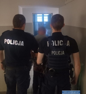 Policjanci prowadzą zatrzymanego