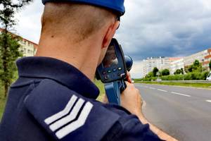 Policjant mierzy prędkość kierujących pojazdami