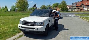 Policjant przy kontrolowanym samochodzie