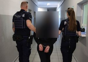 Policjanci prowadzą zatrzymanego