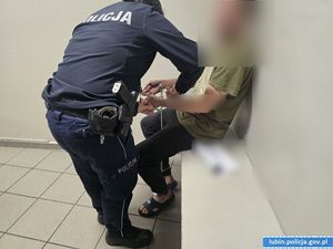 Policjantka zakłada kajdanki zatrzymanemu