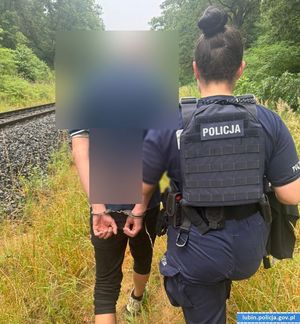 Policjantka prowadzi zatrzymanego mężczyznę