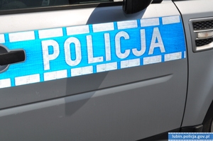 Napis policja na drzwiach radiowozu