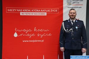 Policjant przy banerze