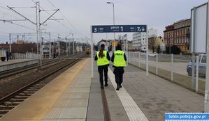 Policjant i policjantka idący peronem kolejowym