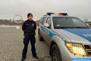 Na zdjęciu widać policjanta stojącego obok radiowozu oznakowanego
