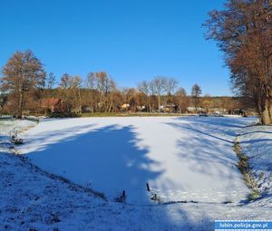 na zdjęciu widać zamarznięty staw pokryty śniegiem