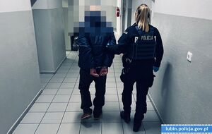 Policjantka prowadzi zatrzymanego