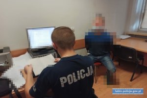 Policjant z zatrzymanym w pokoju.