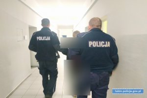 Policjanci prowadzą zatrzymanego